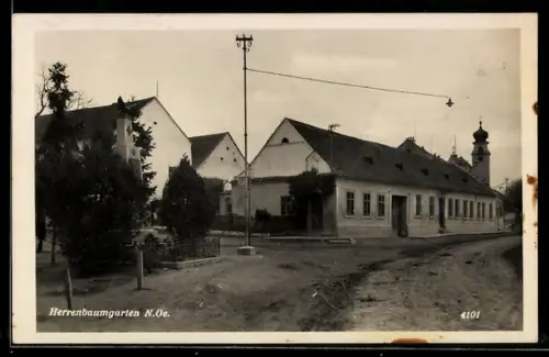 AK Herrenbaumgarten /N.-Oe., Strasse mit Kriegerdenkmal und Blick auf die Kirche