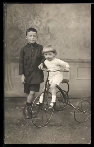 Foto-AK Zwei junge Kinder mit einem Dreirad