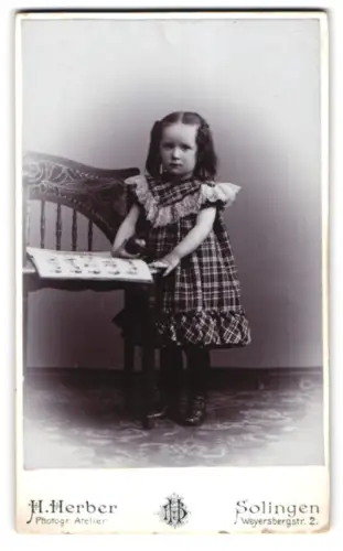 Fotografie H. Herber, Solingen, Weyersbergstr. 2, Portrait von Gretel Lotz mit Bilderbuch und Spielzeug