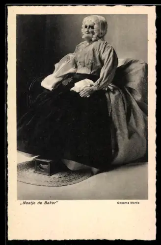 AK Puppe sitzt als alte Frau in einem Sessel, Naatje de Baker