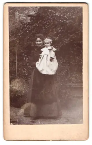 Fotografie unbekannter Fotograf und Ort, Portrait Frau Hanna mit Kind im Garten