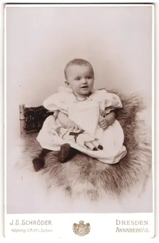 Fotografie J.S. Schröder, Dresden, Reissigerstr. 46, Elsa als Kleinkind mit Puppe auf Fell