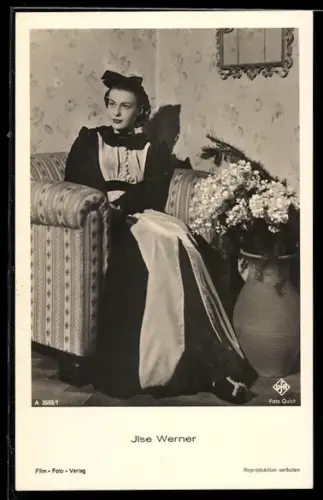 AK Schauspielerin Ilse Werner in einem Sessel und mit Blumen