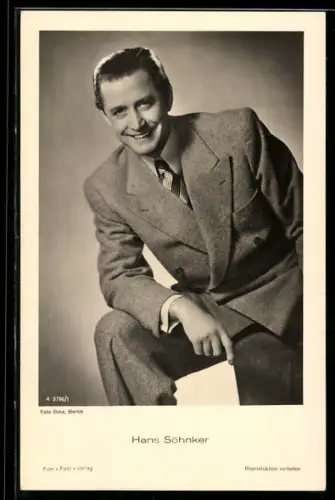 AK Schauspieler Hans Söhnker lächelnd auf dem Bein abstützend