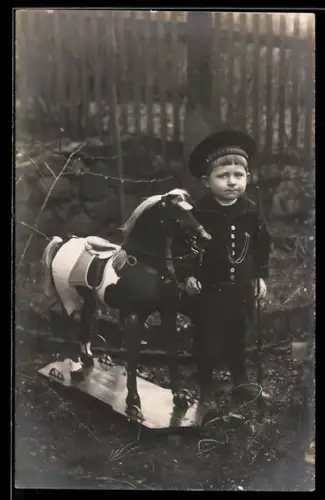 Foto-AK Junge mit Matrosenmütze mit einem Pferd auf Rollen