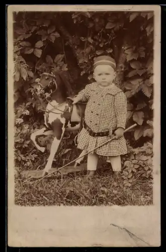 Foto-AK Kleinkind mit Pferd auf Rollen im Garten