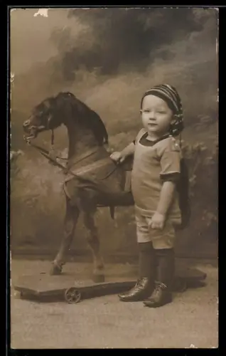 Foto-AK Kleiner Junge mit Spielzeugpferd auf Rollen