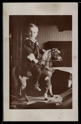 Foto-AK Kleiner Junge sitzt auf seinem Schaukelpferd