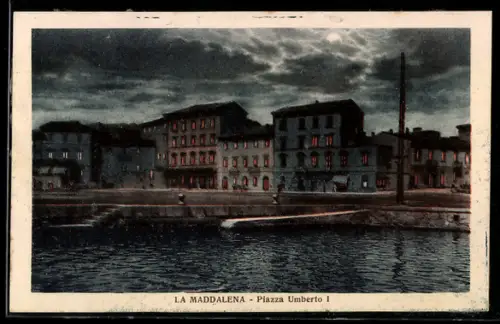 AK La Maddalena, Piazza Umberto I al crepuscolo con edifici illuminati e cielo nuvoloso