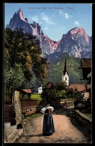 AK Seis am Schlern, Frau in Trachten im Ort, Kirche im Hintergrund