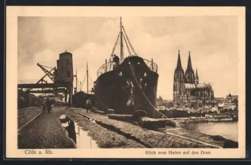 AK Cöln a. Rh., Blick vom Hafen auf den Dom, Frachtschiff an der Kaimauer