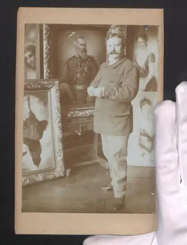 Fotografie Ein Kunstsammler steht stolz vor einem Teil seiner Gemälde