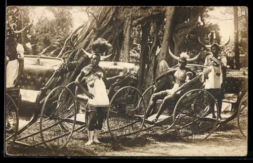 Foto-AK Männer in Stammeskleidung mit Kopfschmuck und Rikschas
