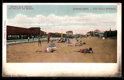 AK Grado, Vita sulla spiaggia con bagnanti e strutture balneari lungo la riva