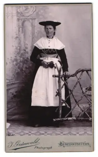 Fotografie J. Grünwald, Benediktbeuern, Junge Frau in deutscher Tracht an einem Zaun