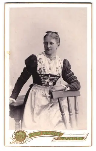 Fotografie Anton Grainer, Traunstein, Stadtplatz, Frau in deutscher Tracht an einem Stuhl lehnend