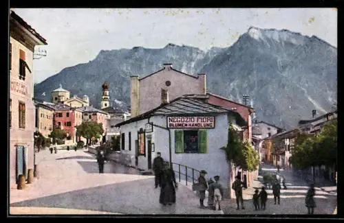 AK Levico /Valsugana, Vista della strada con negozio di fiori e montagne sullo sfondo