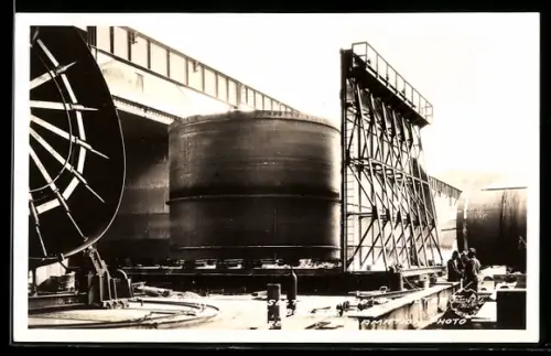 AK Fabrikarbeiter stehen neben einem Tank