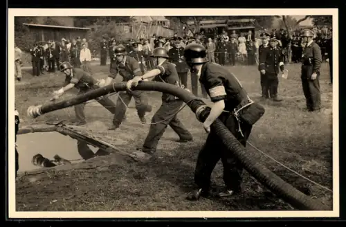 Foto-AK Feuerwehrmänner der Feuerwehr Soltau mit einem Schlauch 1954