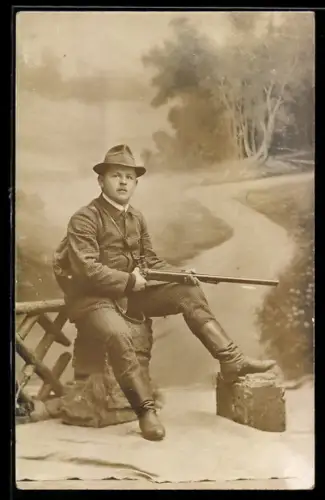 AK Jäger mit Gewehr vor einem Waldstück