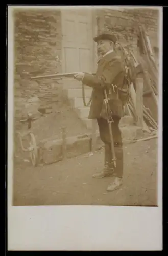 Foto-AK Jäger mit Gewehr vor einem Haus