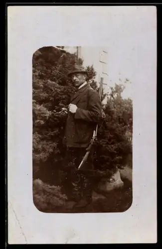 Foto-AK Jäger mit geschultertem Gewehr und Zigarre