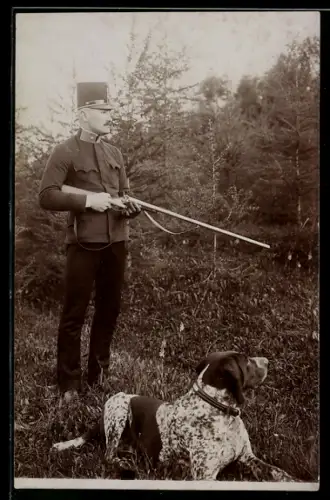 AK Jäger mit Gewehr im Anschlag neben einem Jagdhund