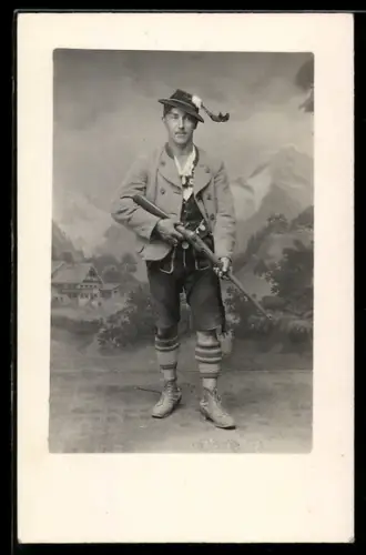 Foto-AK Jäger mit Gewehr und in Tracht vor einer Landschaftskulisse