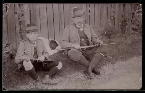 Foto-AK Zwei Jäger mit Gewehren sitzen auf dem Boden