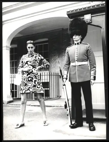 Fotografie Araldo di Crollalanza, Paris, Fotomodell Elizabeth Teissier posiert neben einem Grenadier Guard, 22 x 30cm