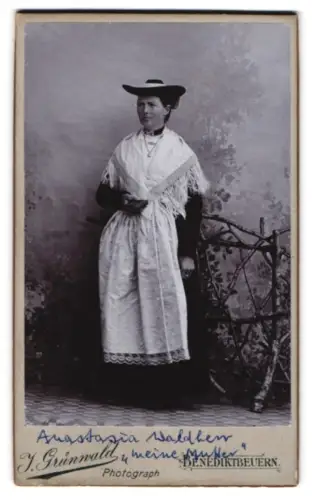 Fotografie J. Grunwald, Benediktbeuern, Anastasia Waldherr in deutscher Tracht neben einem Zaun stehend