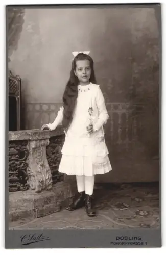 Fotografie Carl Saitz, Wien, Pokornygasse 1, Mädchen mit Schleife im Haar und Kerze zur Kommunion