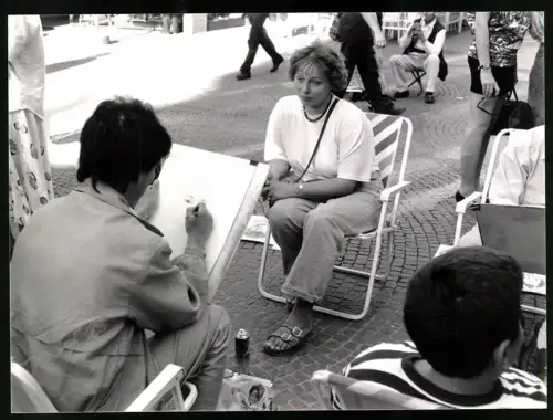 Fotografie Portraitmaler bei der Arbeit auf einem öffentlichen Platz