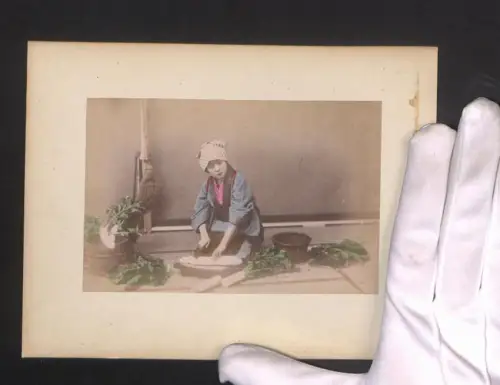 Fotografie Geisha beim Rettichschneiden, Ortspartie mit Brücke und Booten, handkoloriert