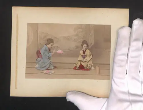 Fotografie Zwei Geisha sitzen vor einem Landschaftsportrait, Landstrasse mit Bauern bei Nikko, handkoloriert