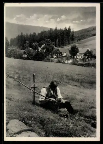 AK Landmann schärft seine Sense auf der Wiese