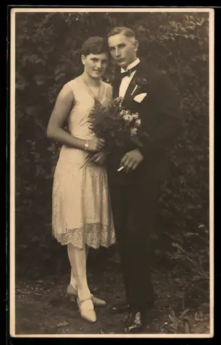 Foto-AK Elegantes Hochzeitspaar in einem Garten, 1929