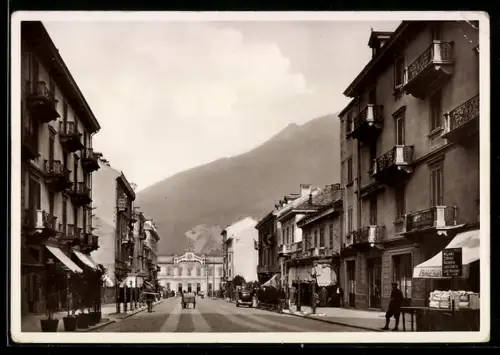 AK Domodossola, Viale Stazione con vista sulla montagna e attività commerciali lungo la strada