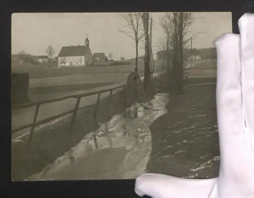 Fotografie Ansicht Kleinneuschönberg, Mann in Uniform an einem kleinen Bach mit Kirche im Hintergrund