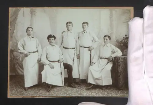Fotografie Gruppenportrait von fünf Metzgern in Arbeitskleidung