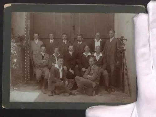 Fotografie Gruppenportrait von Landvermessern mit einem Nivelliergerät