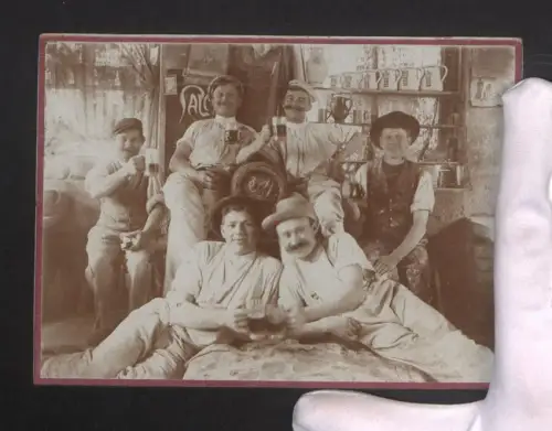 Fotografie Gruppenportrait von jungen Männern mit Schwarzbier in einem Gasthof