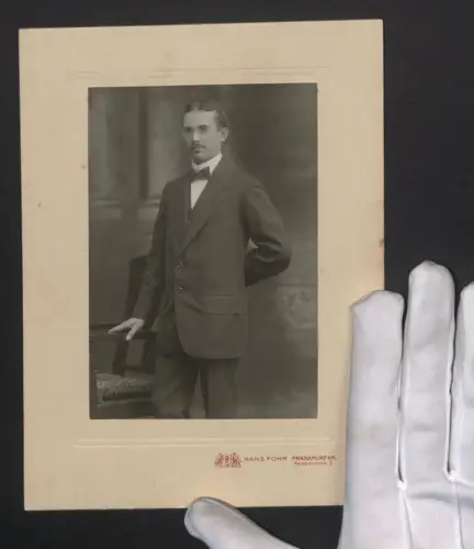 Fotografie Hans Fohr, Frankfurt a. M., Kaiserstrasse 3, Eleganter Herr im Anzug neben einem Stuhl