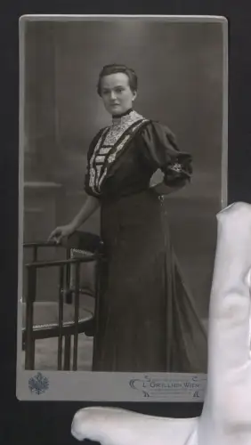 Fotografie L. Grillich, Wien, Wiedner Hauptstrasse 12, Portrait einer Frau mit elegantem Kleid und einem Stuhl