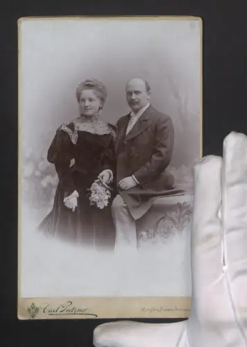Fotografie Carl Pietzner, Wien, Mariahilferstrasse 3, Elegantes Paarportrait mit Blumenstrauss