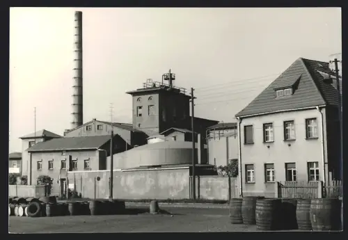Fotografie unbekannter Fotograf, Ansicht Zörbig, Zörbig VEB Ogis, Industriekomplex mit Schornstein und Fässern