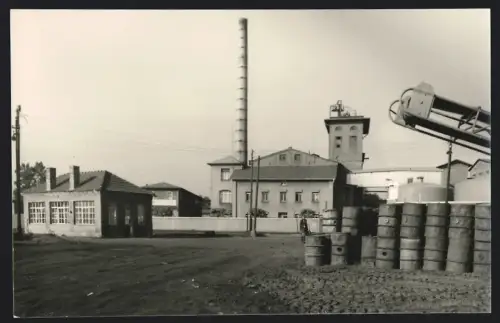 Fotografie unbekannter Fotograf, Ansicht Zörbig, Zörbig VEB Ogis, Industrieanlage mit Schornstein und Fässern