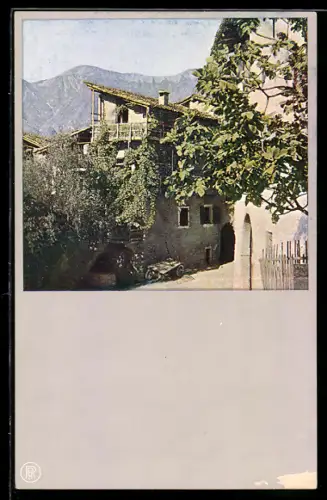 AK Arco, Casa rustica con vegetazione e montagne sullo sfondo