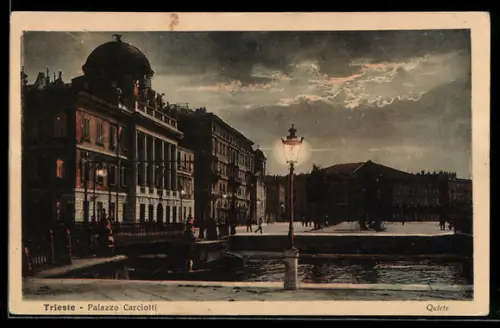 AK Trieste, Palazzo Carciotti di notte con lampione e cielo nuvoloso