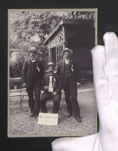 Fotografie Gruppenportrait dreier Männer in Anzügen mit Kriegervereinsabzeichen, Schild Omararu